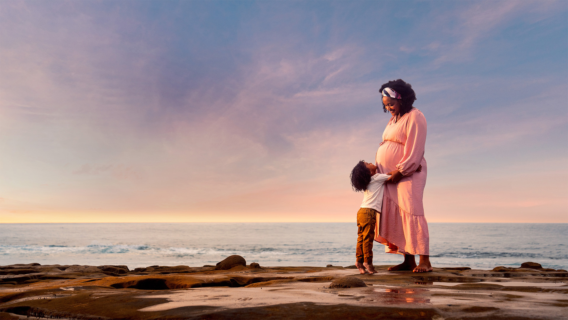 Mom and son standing by ocean